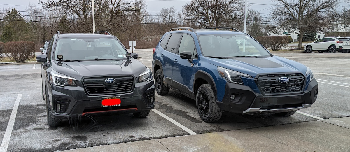 dark gray Subaru Forester Sport parked next to a blue Forester Wilderness